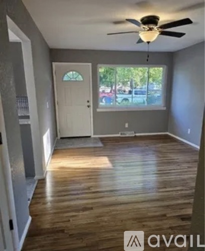 A room with wooden floors and a ceiling fan.