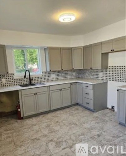 A kitchen with a tiled backsplash and a window.