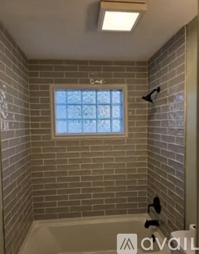 A bathroom with a window in the shower area.
