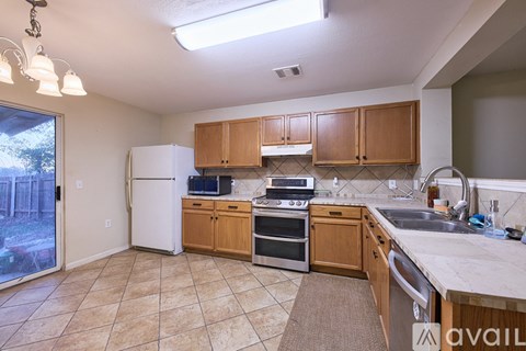 A kitchen with wooden cabinets and a white refrigerator.