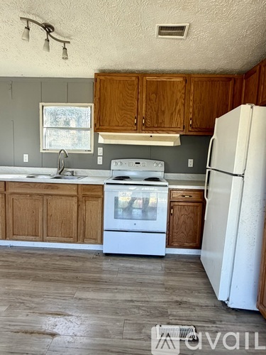 A kitchen with a white fridge and a white dishwasher.