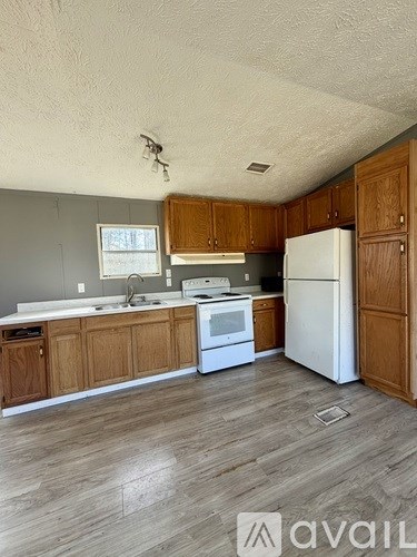 A kitchen with wooden cabinets and white appliances.