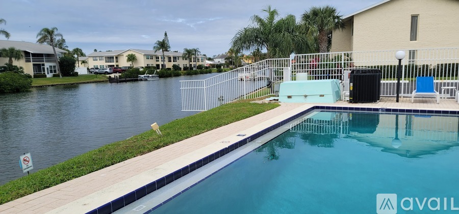 A pool with a blue tiled edge and a white fence.