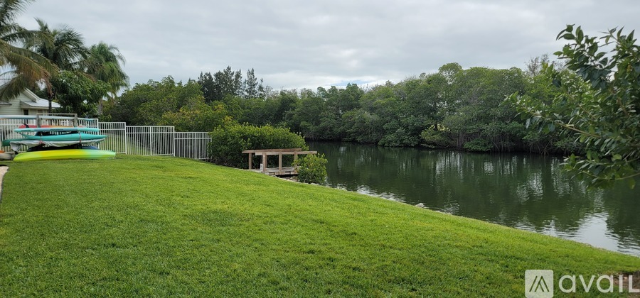 A grassy area with a body of water and a dock.