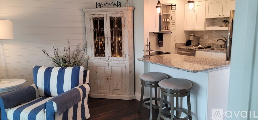 A kitchen with a striped chair and a wooden cabinet.