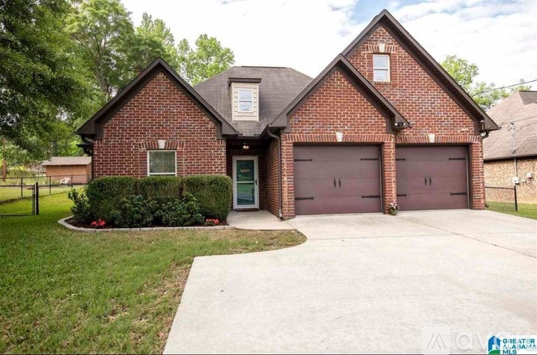 A brick house with a garage door and a driveway.