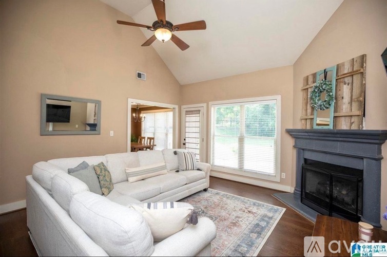 A living room with a white couch and a fireplace.