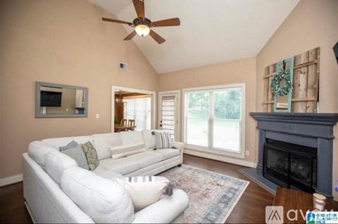 A living room with a white couch and a fireplace.