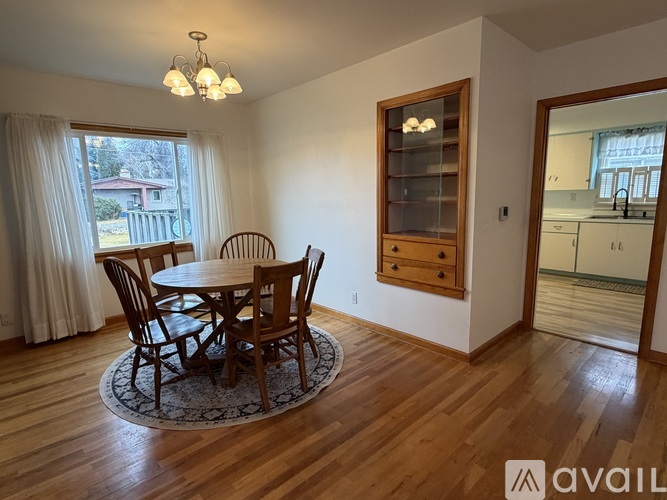 A dining room with a round table and chairs.