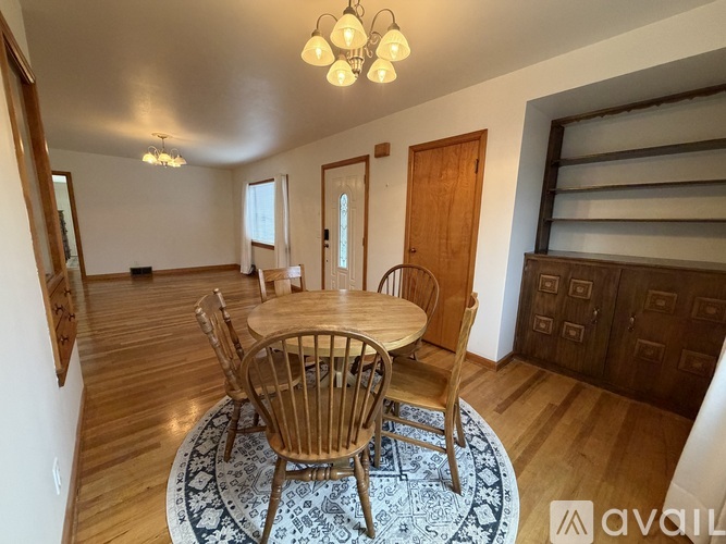 A dining room with a round wooden table and chairs.