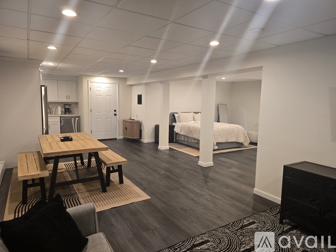 A modern living room with a wooden table and a black couch.