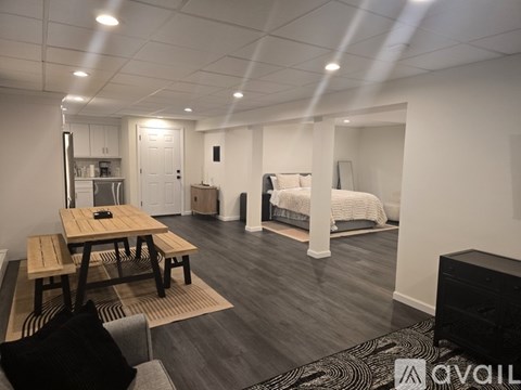 A modern living room with a wooden table and a black couch.