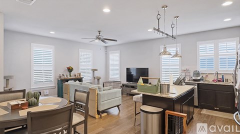 A well-lit living room with a dining table and chairs.