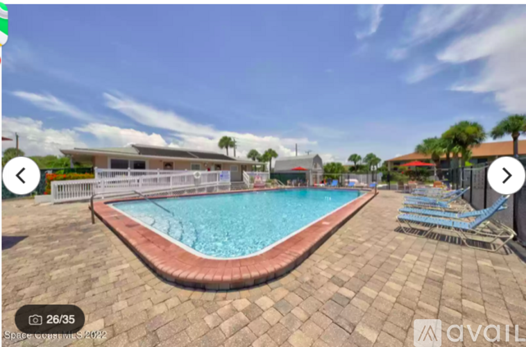 A swimming pool surrounded by a brick patio.