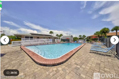 A swimming pool surrounded by a brick patio.