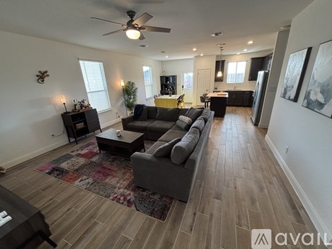 A living room with a grey couch and a rug.