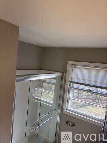 A kitchen with a glass door refrigerator and a window.