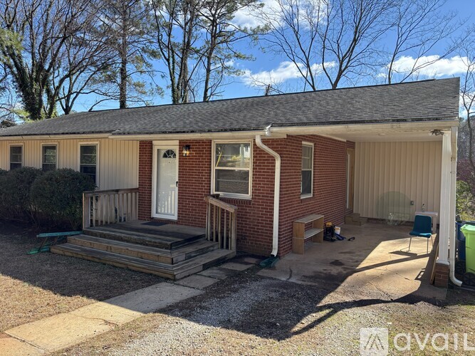 A house with a red brick exterior and a white door is for sale.