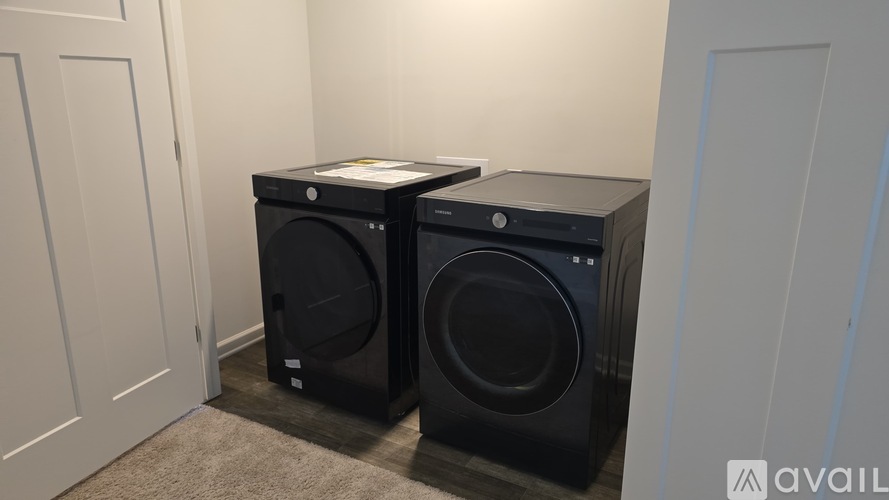 Two black washing machines in a room.