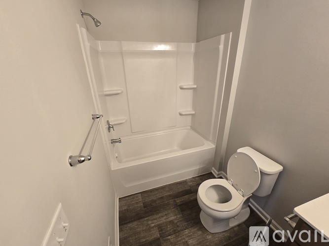 A white toilet sits next to a walk-in shower.