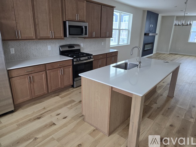 A kitchen with wooden cabinets and a white island.