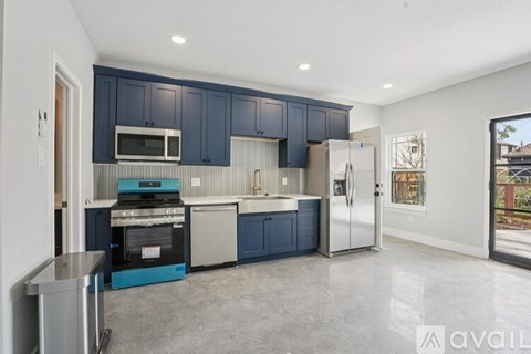 A kitchen with blue cabinets and stainless steel appliances.