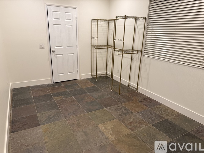 A room with a white door and a tiled floor.