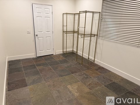 A room with a white door and a tiled floor.