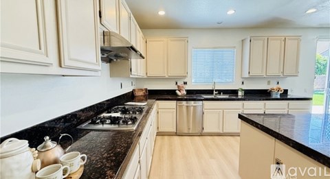 A kitchen with a black countertop and wooden cabinets.