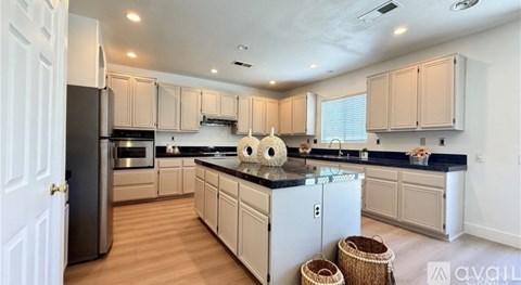 A kitchen with wooden cabinets and a black refrigerator.