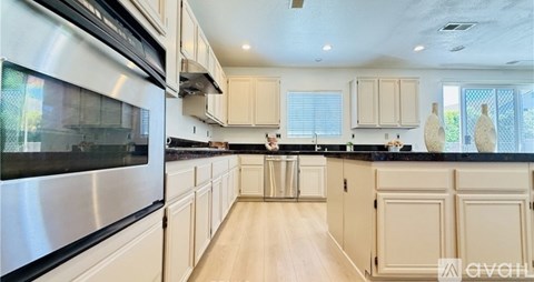 A modern kitchen with wooden cabinets and a stainless steel refrigerator.