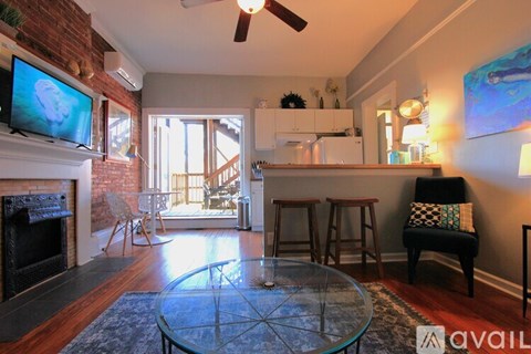 A living room with a glass table and a television on the wall.