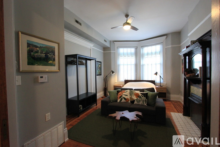 A bedroom with a bed, a chair, and a painting on the wall.