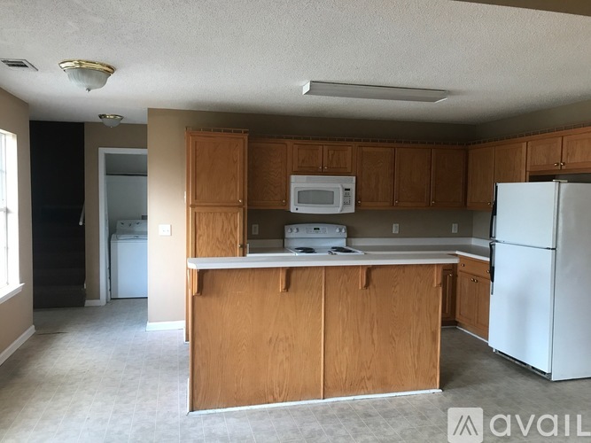 A kitchen with wooden cabinets and a white refrigerator.