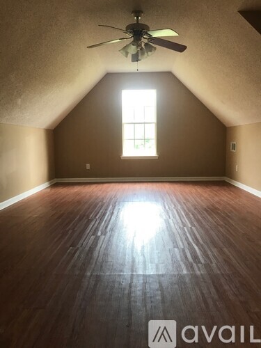 A room with a window and a ceiling fan.