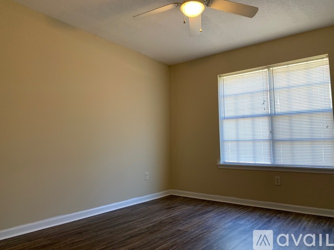 A room with a ceiling fan and a window with blinds.