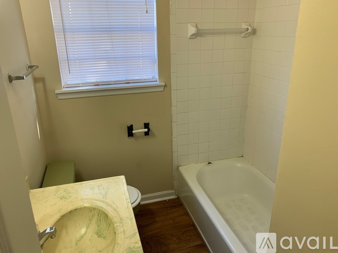 A bathroom with a tub, toilet, and sink.