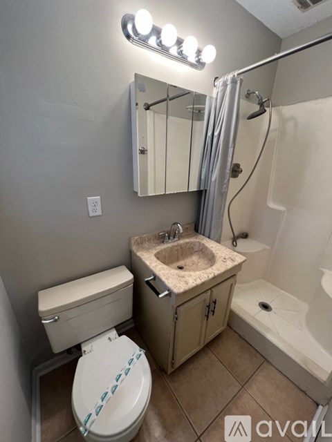 A bathroom with a toilet, sink, and mirror.