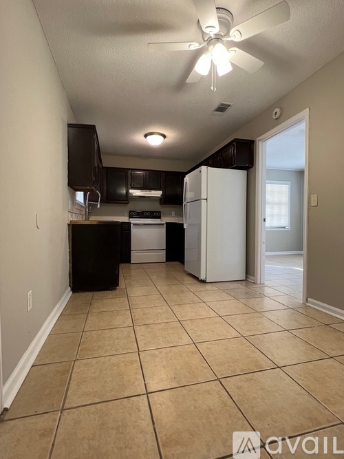 A kitchen with a white refrigerator and black appliances.