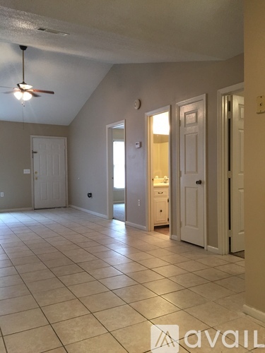 A room with a fan and tile flooring.