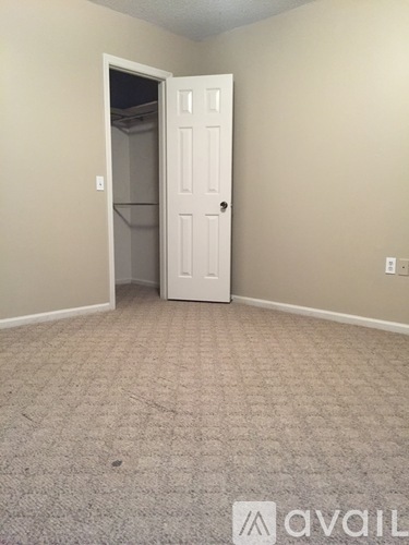 A room with a carpeted floor and a white door.