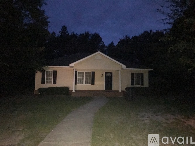 A house with a front yard and a pathway leading to the front door.