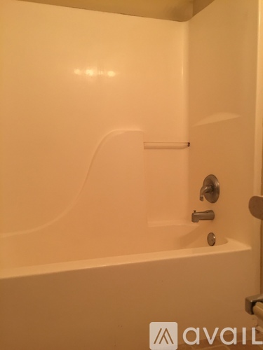 A white bathroom with a tub and a shower.