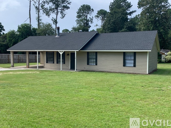 A house with a black roof and a porch is for sale.