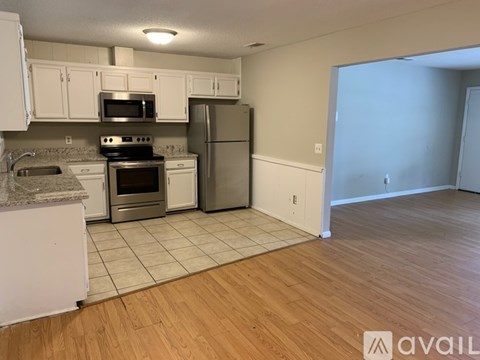 A kitchen with white cabinets and a stainless steel refrigerator.
