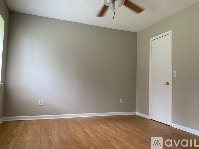 A room with a ceiling fan and a door.