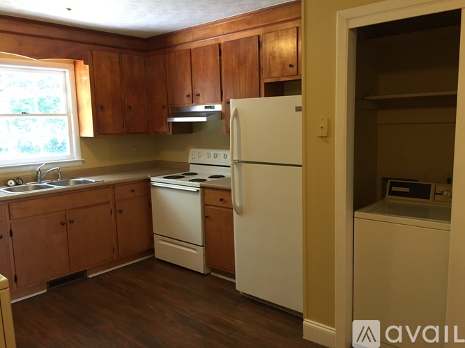 A kitchen with wooden cabinets and a white refrigerator.