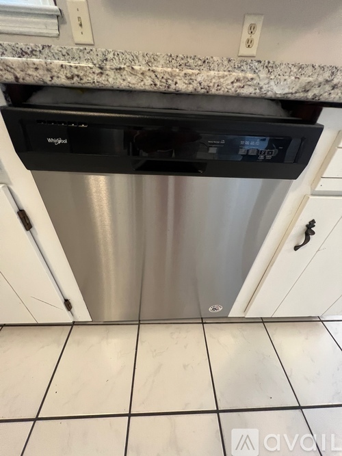 A Whirlpool dishwasher is installed under a granite countertop.