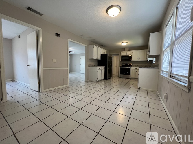 A kitchen with white tile flooring and white walls.