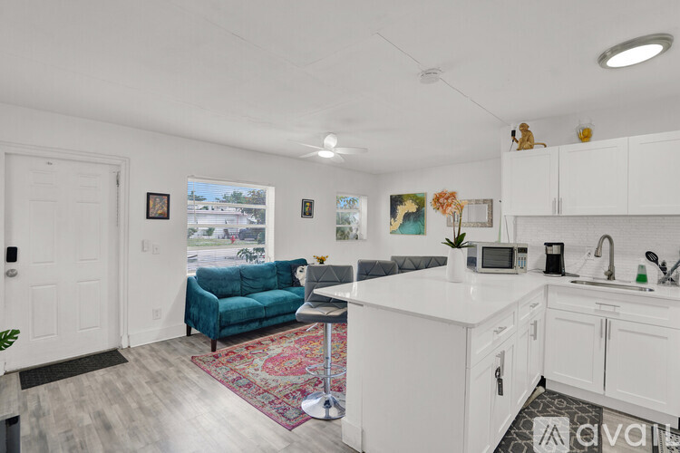 A kitchen with white cabinets and a blue couch.